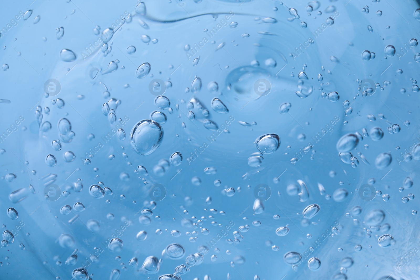 Photo of Sample of light blue cosmetic gel as background, closeup