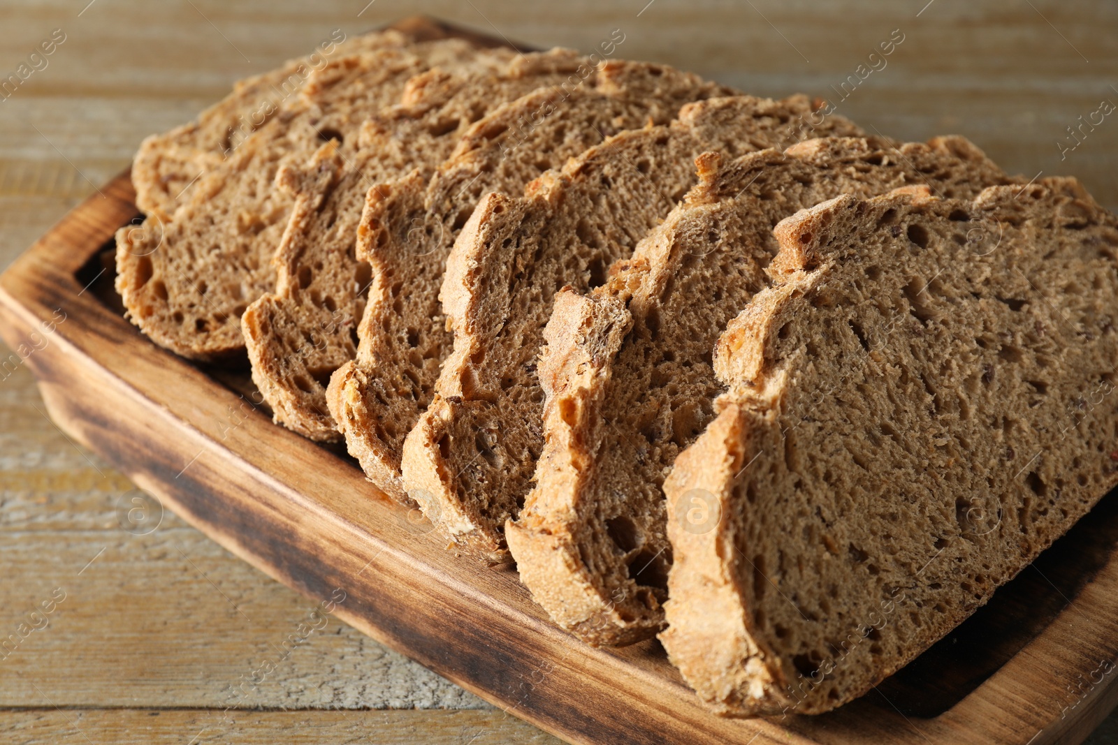 Photo of Freshly baked cut sourdough bread on wooden table, closeup