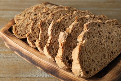 Freshly baked cut sourdough bread on wooden table, closeup