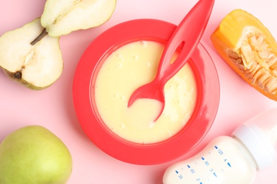 Photo of Baby food in bowl and fresh ingredients on pink background, flat lay