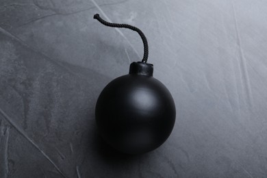 Photo of Sphere shaped bomb with burning fuse on black background, top view
