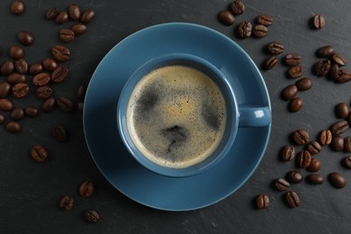Photo of Cup of aromatic coffee and beans on grey table, top view