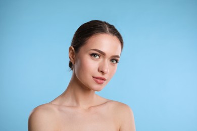 Portrait of beautiful woman on light blue background