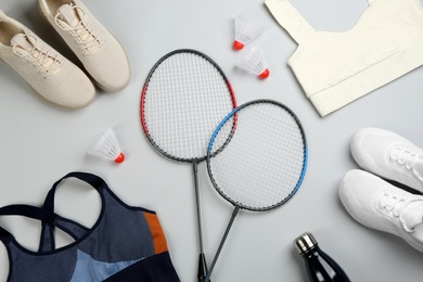 Flat lay composition with rackets and shuttlecocks on light grey background. Playing badminton