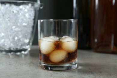 Photo of Delicious cocktail with ice balls on grey table