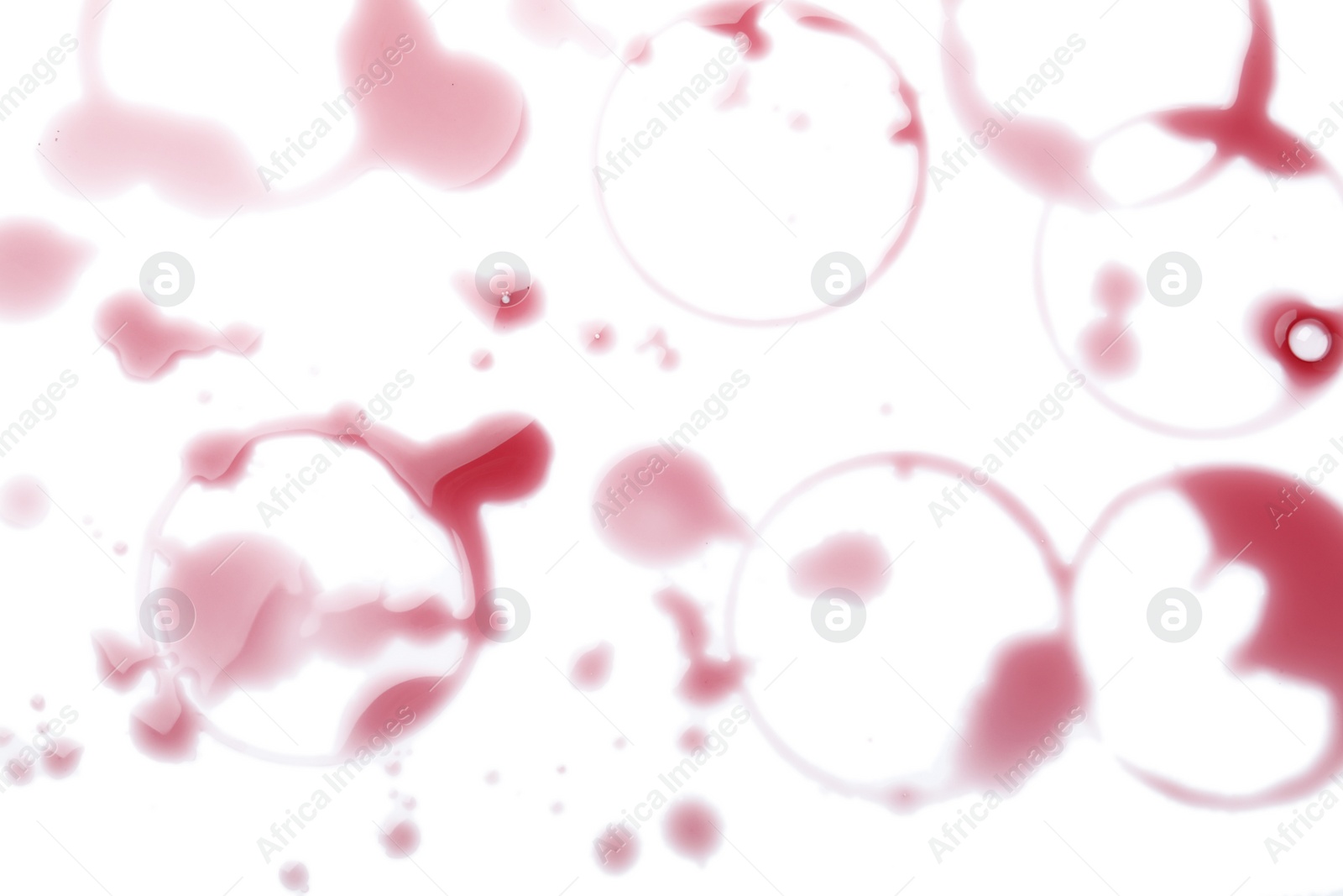 Photo of Many red wine rings and drops on white background, top view