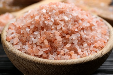 Pink himalayan salt in wooden bowl on table, closeup