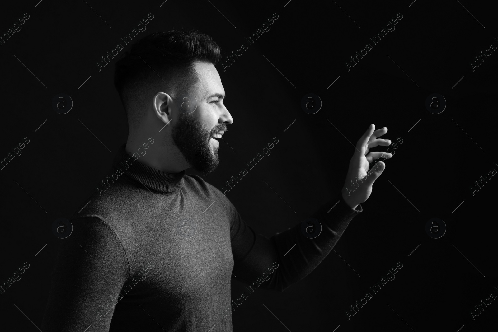 Photo of Portrait of handsome bearded man on dark background. Black and white effect