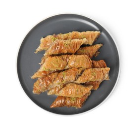 Photo of Plate of delicious baklava with pistachios isolated on white, top view