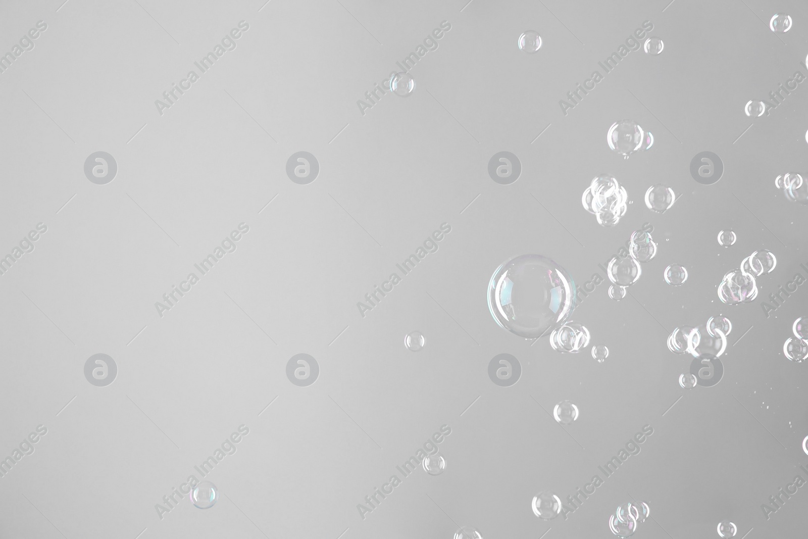 Photo of Beautiful transparent soap bubbles on grey background, space for text