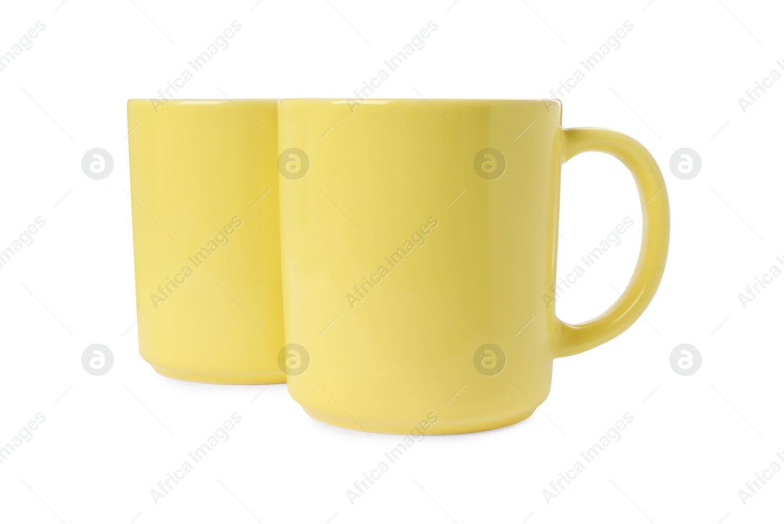 Photo of Two yellow ceramic mugs isolated on white