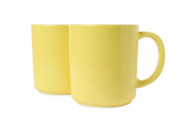 Photo of Two yellow ceramic mugs isolated on white