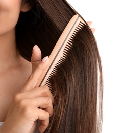 Young woman with wooden hair comb on white background, closeup