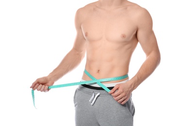 Photo of Young man with measuring tape showing his slim body on white background, closeup