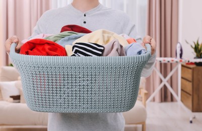 Photo of Man with basket full of laundry at home, closeup