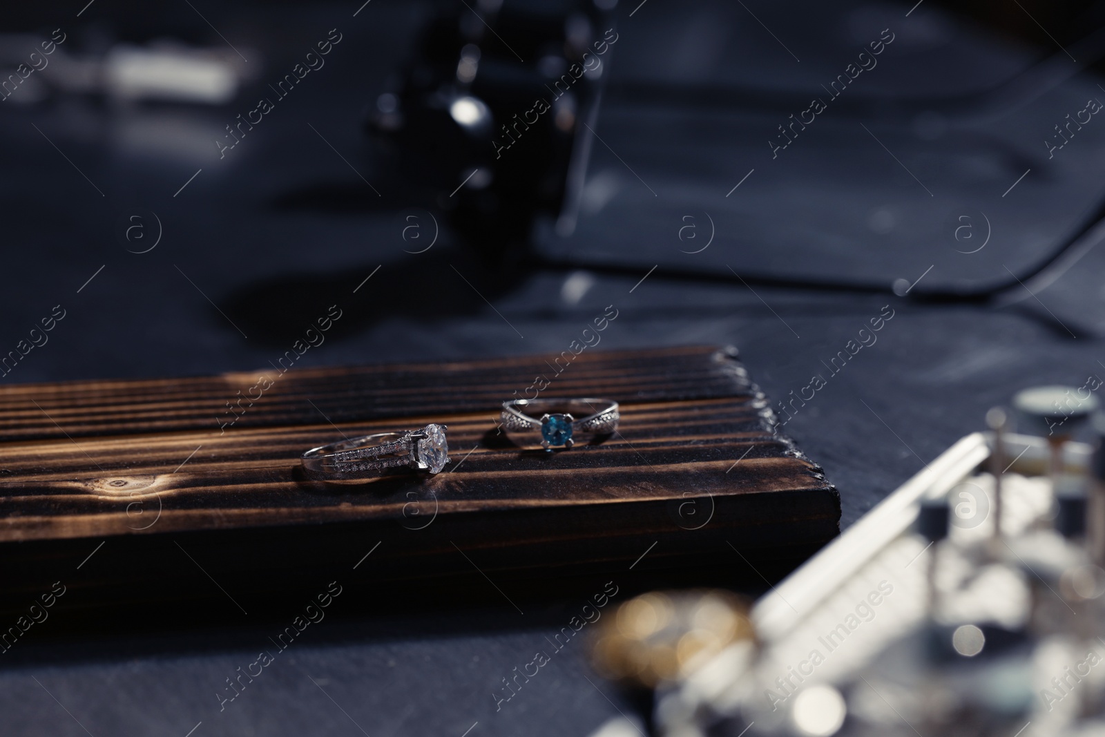 Photo of Beautiful silver rings on black table. Jeweler's workshop