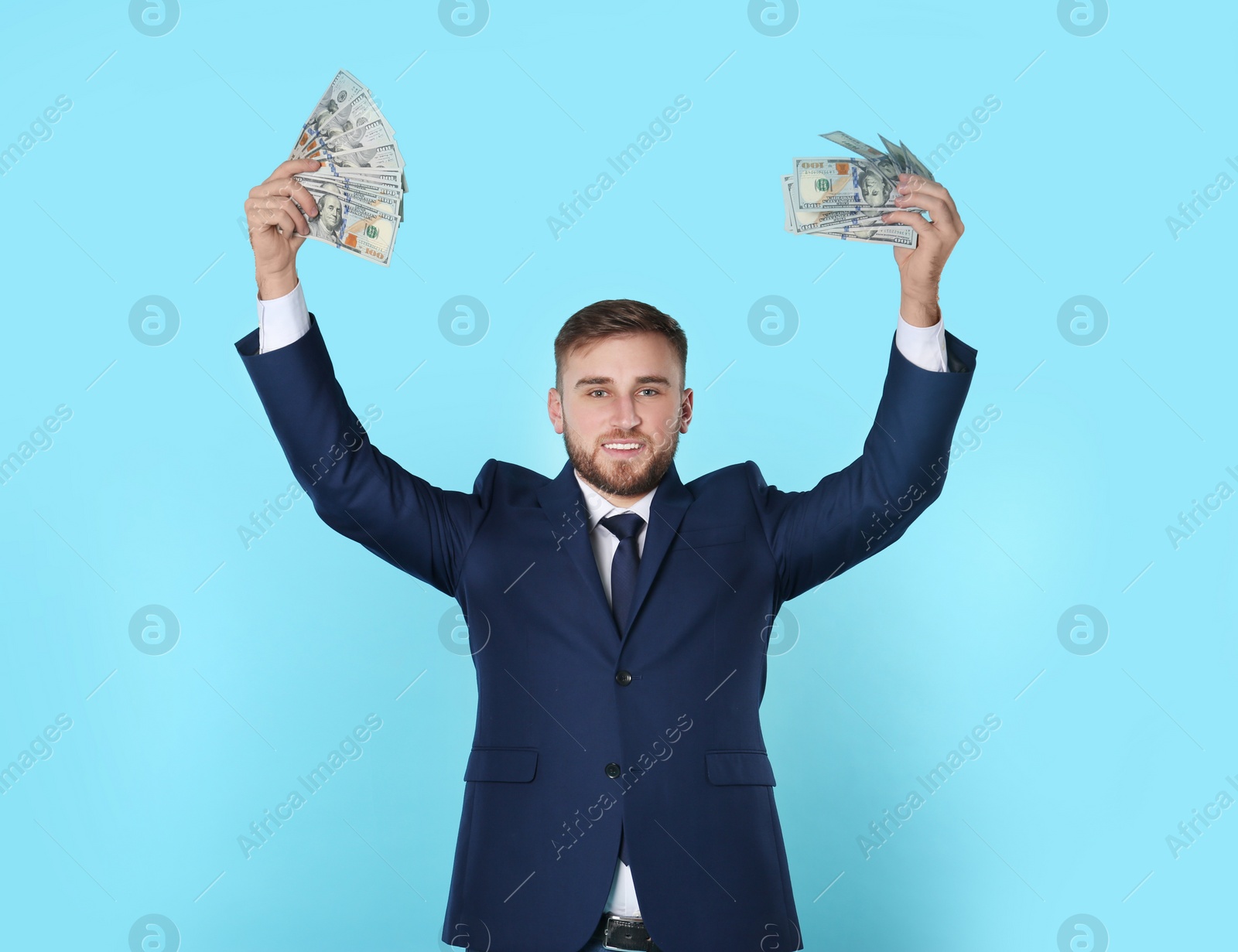 Photo of Portrait of happy young businessman with money on color background