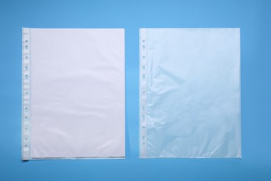 Photo of Punched pockets on light blue background, flat lay. Space for text