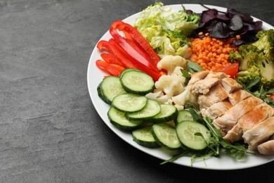 Photo of Balanced diet and healthy foods. Plate with different delicious products on black table, closeup. Space for text