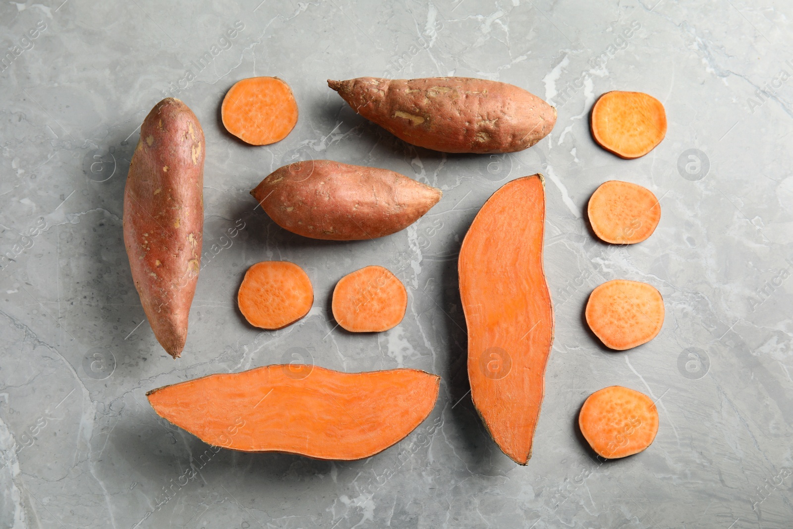 Photo of Flat lay composition with sweet potatoes on grey background