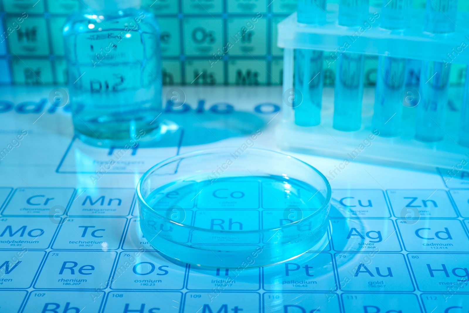 Photo of Petri dish on periodic table of elements, closeup. Color tone effect