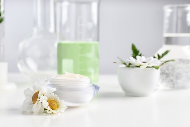 Photo of Skin care product, ingredients and laboratory glassware on table, space for text. Dermatology research