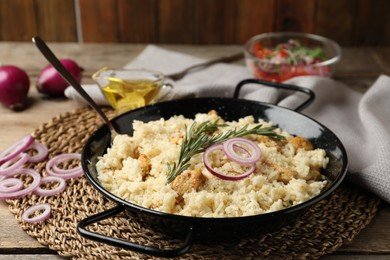 Photo of Delicious chicken risotto served on wooden table