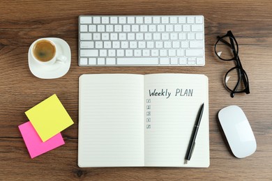 Photo of Flat lay composition of notebook with weekly plan on wooden table