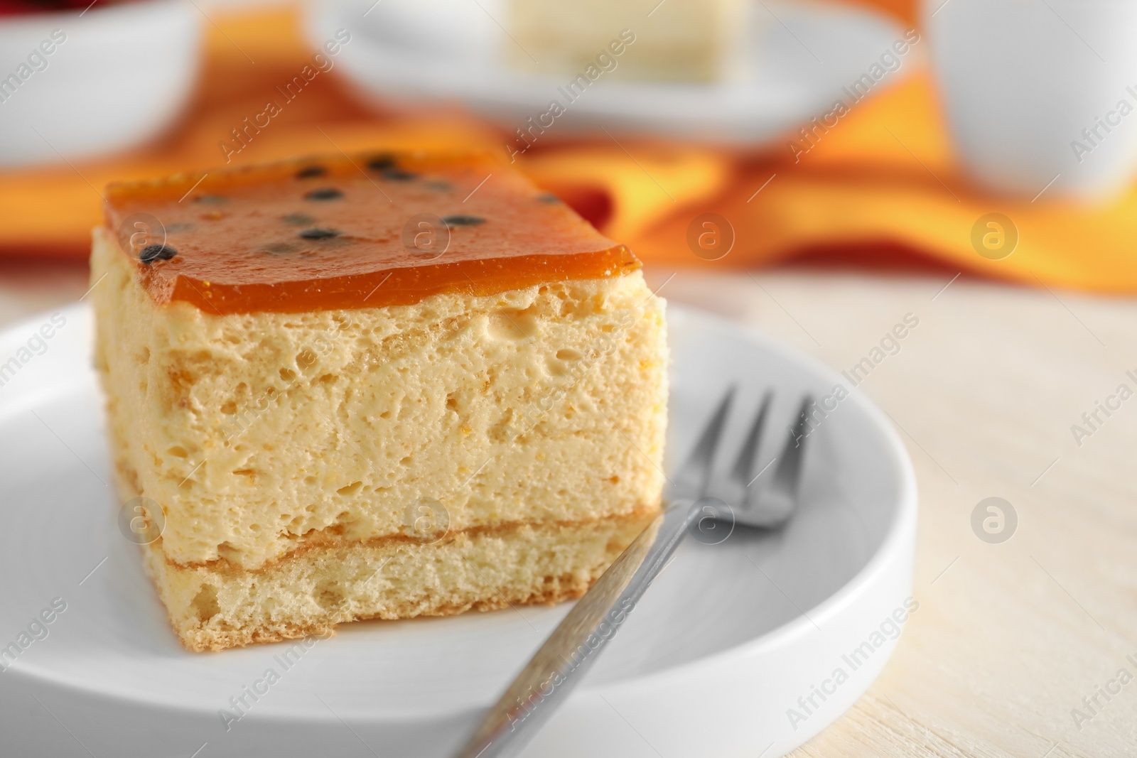 Photo of Piece of cheesecake with jelly and fork on table, closeup with space for text