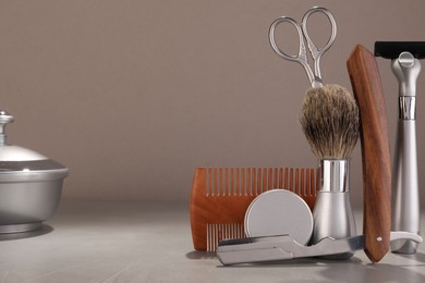 Photo of Moustache and beard styling tools on grey table. Space for text