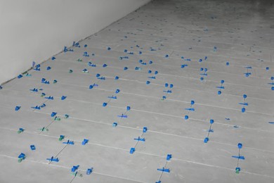 Photo of Beautiful tiles with colorful wedges on floor near wall