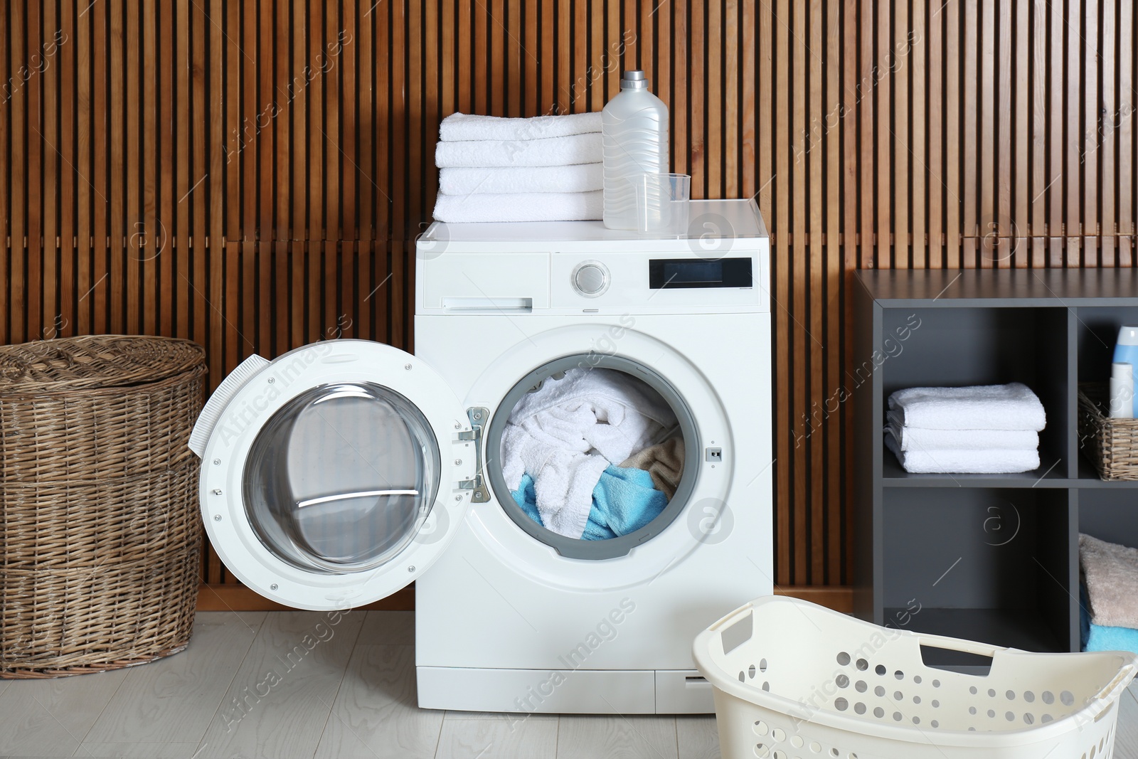 Photo of Crumpled towels in washing machine at home. Laundry room interior