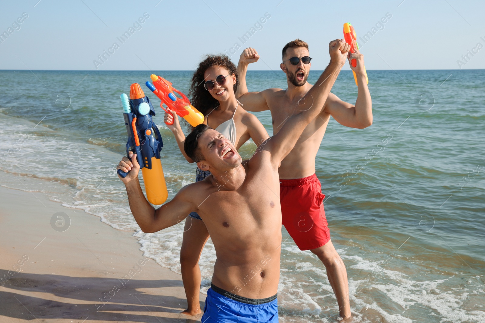 Photo of Friends with water guns having fun on beach