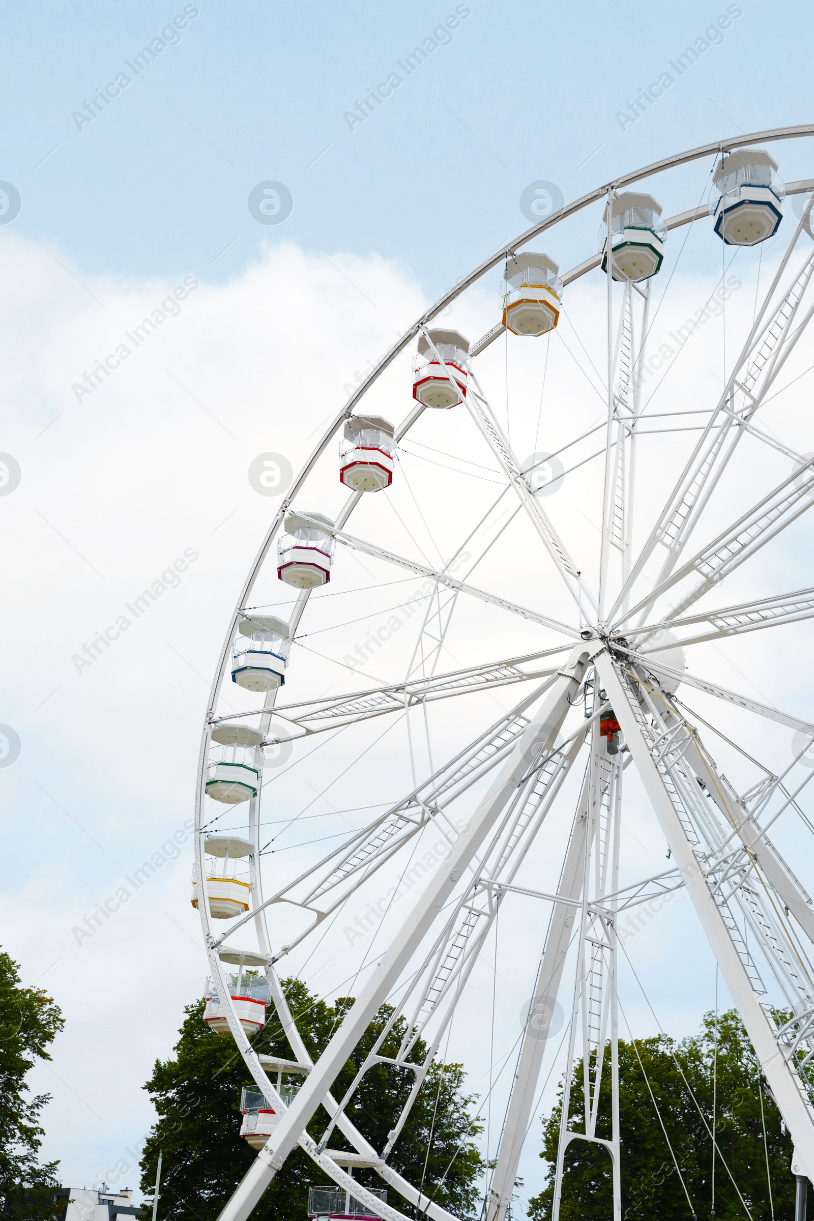 Photo of Large white observation wheel with cabins against sky