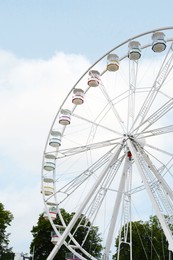Photo of Large white observation wheel with cabins against sky