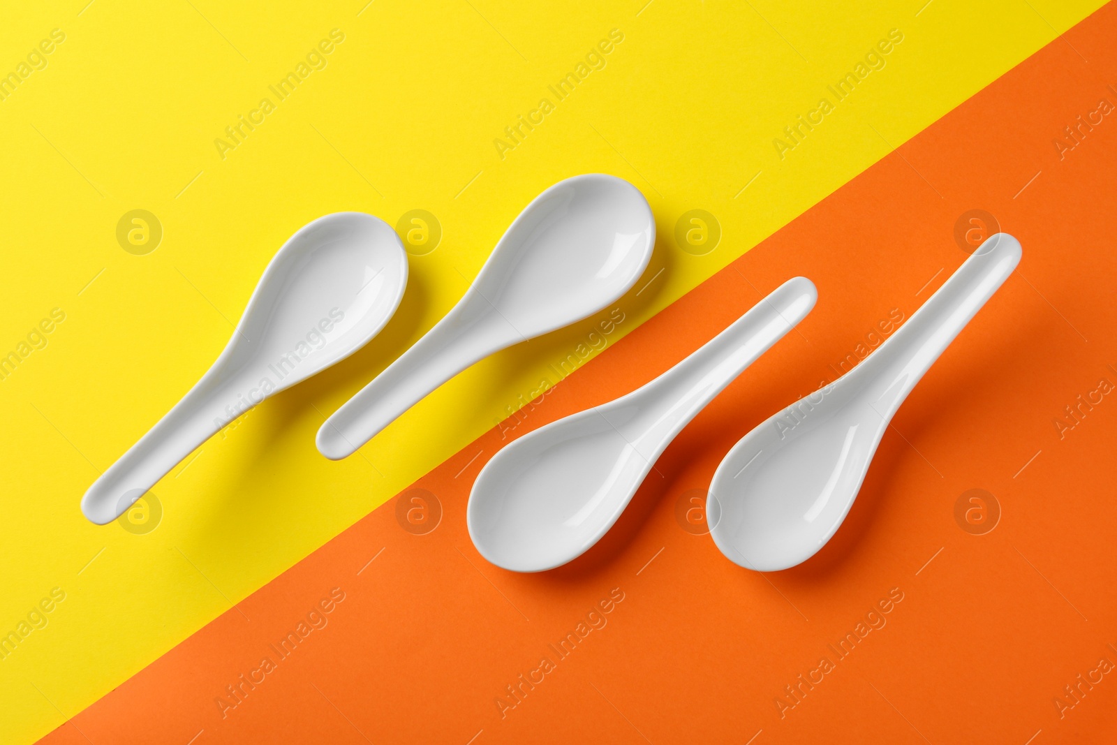 Photo of Miso soup spoons on color background, flat lay