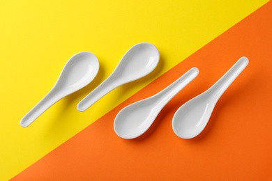 Photo of Miso soup spoons on color background, flat lay