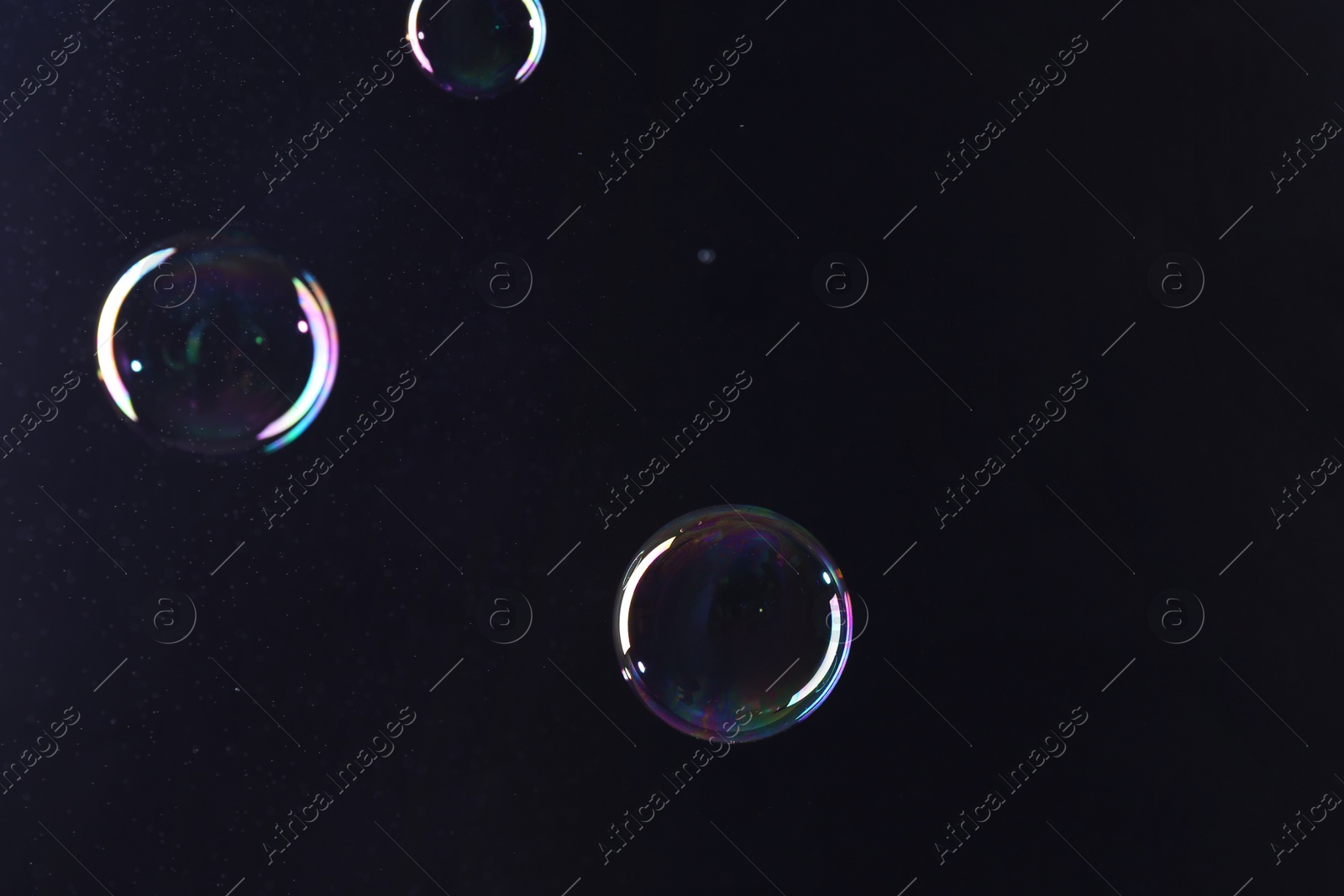 Photo of Beautiful transparent soap bubbles on dark background