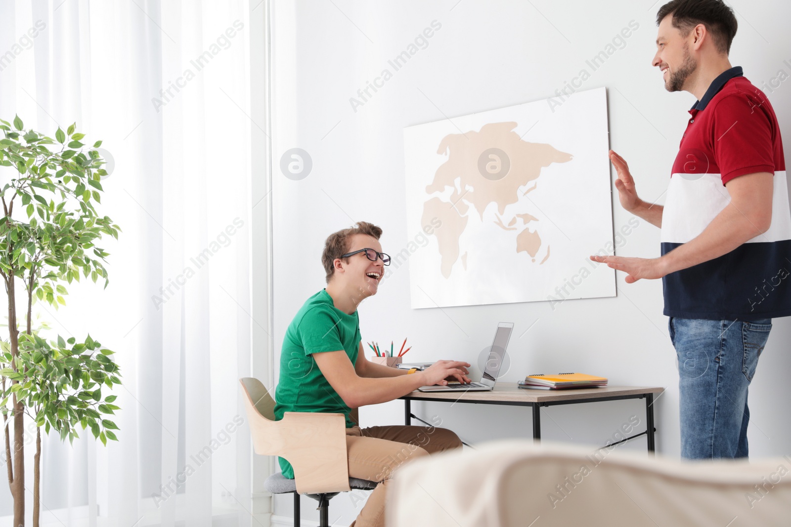 Photo of Father talking with his teenager son at home