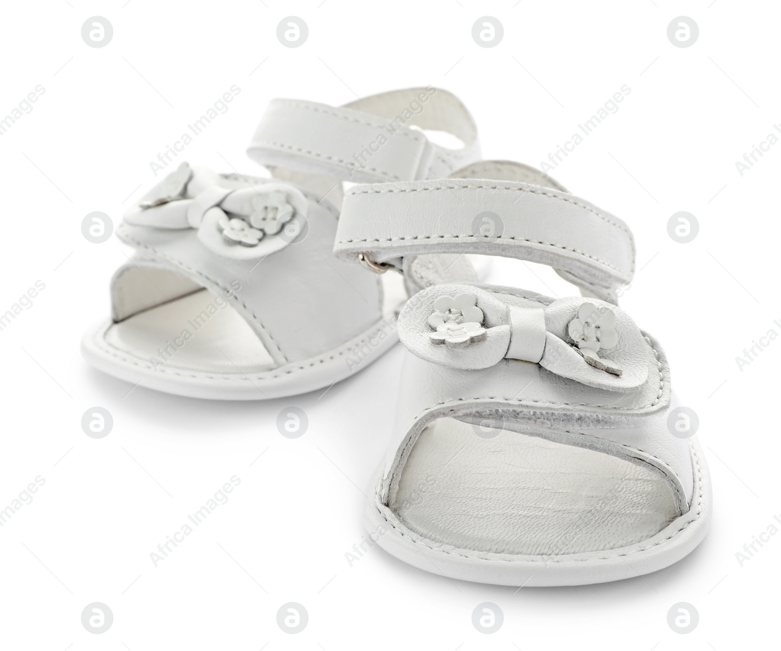 Photo of Pair of cute baby sandals decorated with bows on white background