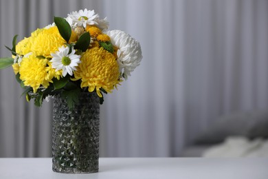 Photo of Bouquet of beautiful chrysanthemum flowers on table in room, space for text