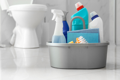 Photo of Cleaning supplies and toilet bowl in bathroom