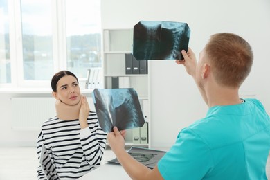Photo of Doctor with neck MRI images consulting patient in clinic