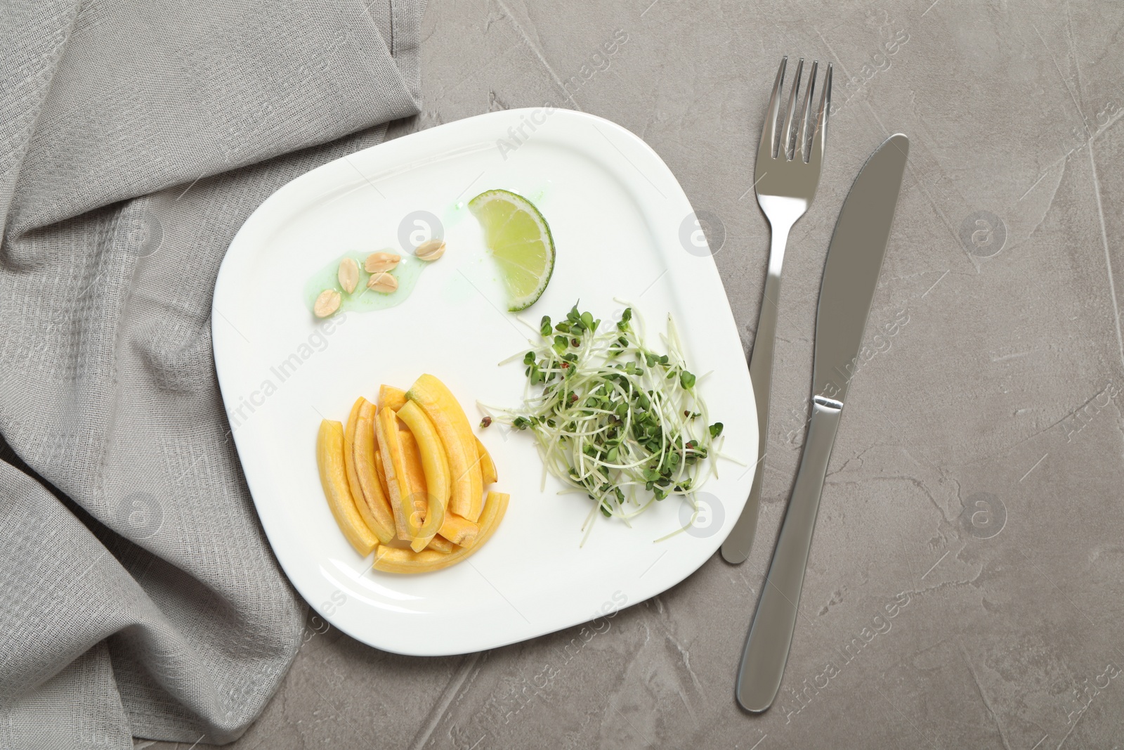 Photo of Delicious fresh carrot salad served on grey table, flat lay