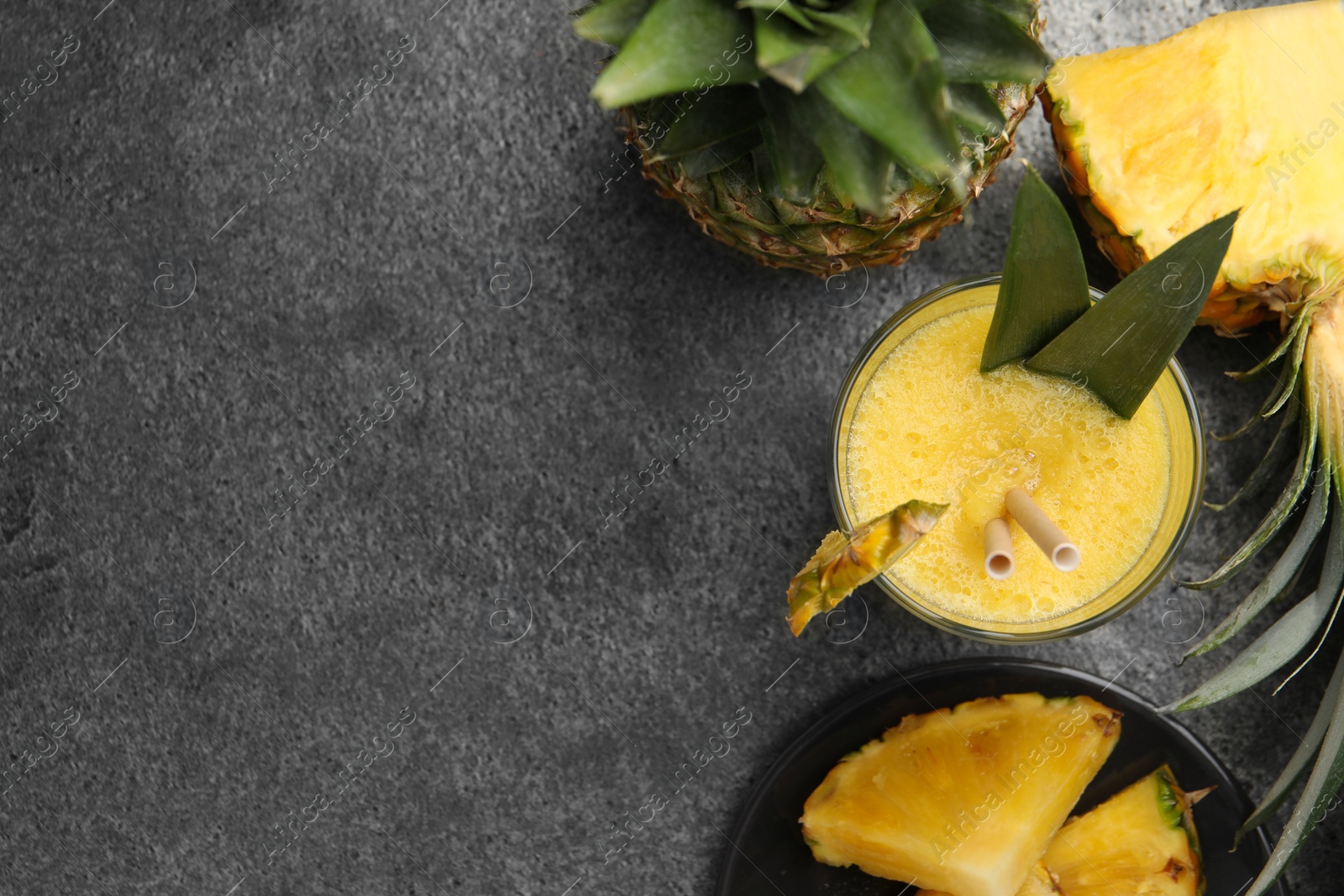 Photo of Tasty pineapple smoothie and fruit on grey table, flat lay. Space for text