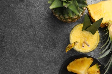 Tasty pineapple smoothie and fruit on grey table, flat lay. Space for text