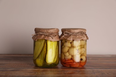 Jars with pickled vegetables on wooden table