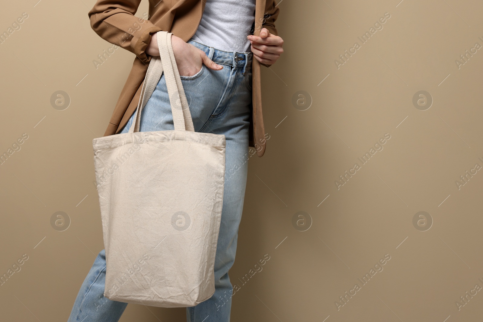 Photo of Woman with eco bag on beige background, closeup. Space for text