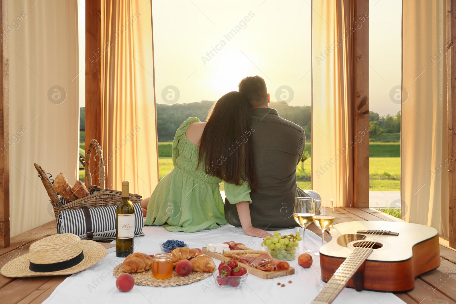 Photo of Romantic date. Couple spending time together during picnic on sunny day, back view