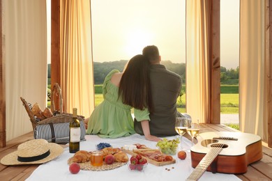 Photo of Romantic date. Couple spending time together during picnic on sunny day, back view